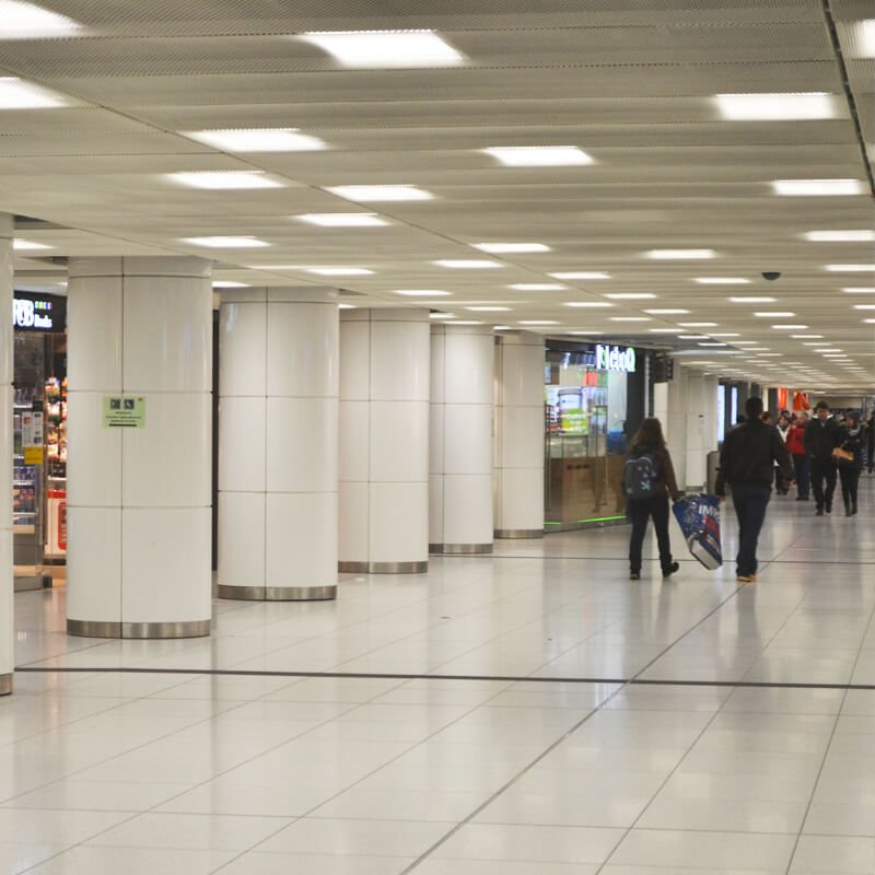 Round aluminum column cover CC200 with seamless snap-fit segments in a transit hall